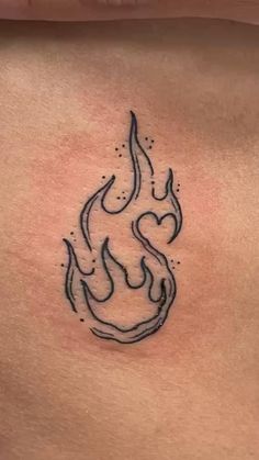 a tattoo on the back of a woman's stomach that has flames coming out of it