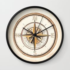 a wall clock with a compass on the front and side of it's face