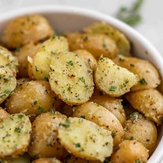 a white bowl filled with potatoes covered in seasoning