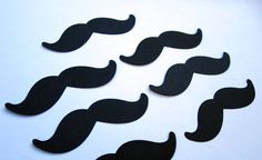 several black mustaches are arranged on a white surface