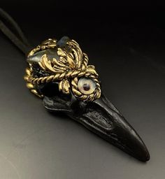 This is a handmade polymer clay Raven skull pendant, with a Labradorite crescent moon and a third eye glass bead. The gold parts are polymer clay finished with a gold colour aluminium leaf.  The pendant comes with a strong suede type cord that can be tied at the back of the neck. The cord measures 38cm from the pendant loop to the end of the cord, so gives plenty of room to tie up. Do feel free to ask me for a longer cord if you want the pendant to hang lower.  This is a hand sculpted item and although polymer clay is a strong material, it should be treated with care. Don't wear the pendant for swimming or in the shower and remove before going to bed. Handmade Resin Jewelry For Halloween, Adjustable Spiritual Polymer Clay Jewelry, Spiritual Adjustable Polymer Clay Jewelry, Handmade Polymer Clay Halloween Jewelry, Black Bohemian Polymer Clay Jewelry, Handmade Crescent Resin Jewelry, Collectible Handmade Resin Jewelry, Bohemian Black Polymer Clay Jewelry, Bohemian Black Jewelry Made Of Polymer Clay