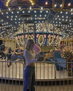 a woman standing in front of a merry go round