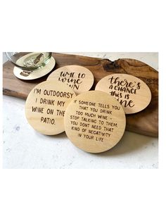 four wooden coasters with words on them