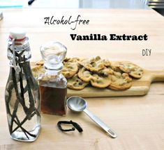 a bottle of vanilla extra next to some cookies and spoons on a wooden table