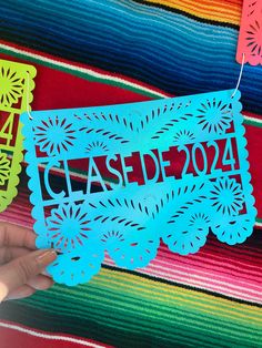 a person holding up a cut out paper with the word class d204 on it