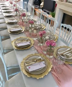 the table is set with pink and gold place settings