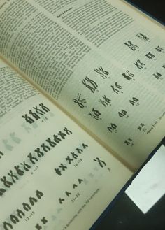 an open book with chinese writing on it and a cell phone in front of it