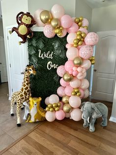 the balloon arch is decorated with pink, gold and white balloons for a baby's first birthday