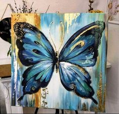 a painting of a blue butterfly sitting on top of a table