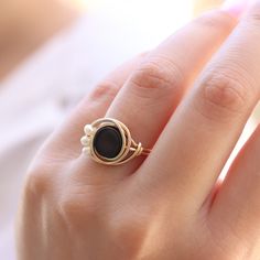 The perfect combination between Black and White This unique wire ring is set with a genuine Black onyx and three Fresh water pearls ☆ WHY THIS PIECE OF J E W E L R Y IS AWESOME! ☆ * Hand finished and made from high quality raw materials * Long lasting beauty & Timeless design ♡ WRAPPING ♡ * All 23 Summers jewels arrive in a cute pouch or gift box so they are gift ready. DELIVERY ✉ * Most items are ready made but some are made to order, Times for each items are shown on * Well packaged for do Adjustable Onyx Rings With Black Enamel, Adjustable Black Enamel Onyx Rings, Elegant Adjustable Onyx Rings, Elegant Wire Wrapped Promise Ring, Elegant Wire Wrapped Round Rings, Elegant Black Opal Ring For Gift, Elegant Black Opal Ring As Gift, Black Hand Wrapped Round Jewelry, Elegant Black Opal Ring Gift