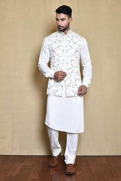 White sleeveless mandarin collar bundi in silk base with ivy bloom embroidery details. Paired with a full sleeves cross cut hem plain white silk kurta and churidar pant. - Aza Fashions Bloom Embroidery, Kurta Patterns, Kurta Set For Men, Silk Kurta, Nehru Jackets, Silk Embroidery, Churidar, Kurta Set, White Sleeveless