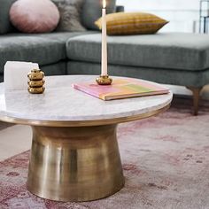 a living room with a couch, coffee table and two candles on top of it