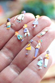 small miniature figurines are displayed in the palm of a person's hand