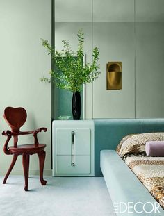 a bed room with a neatly made bed and a plant in a vase on the nightstand