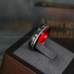 a black and red ring sitting on top of a wooden box