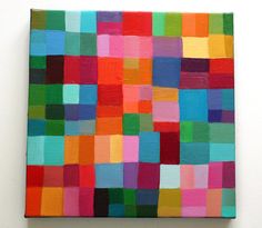 a colorful painting on a wall with white walls and flooring in the background, it is made up of multicolored squares