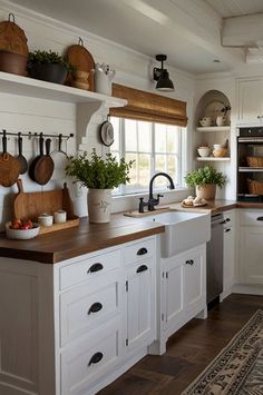 a kitchen filled with lots of white cabinets and wooden counter tops next to a window