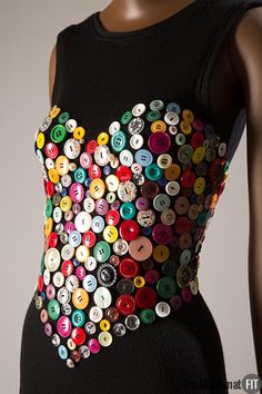 a mannequin wearing a black top with buttons on it