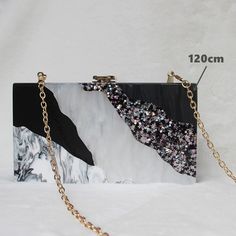 Editor's Notes: A delicate combination of tones. A rectangular clutch with a geometrical pattern. The surface has a raw water-like texture and a resin-like look. This clutch is sure to grab attention. There is enough room for all your essentials. The clutch comes with two chains: a short one to carry the clutch as a handbag and a long one to carry the clutch on the shoulder. Size 7 x 4.3 x 2 inches (18 x 11 x 5 cm) Material PVC, polyester, and acrylic Details Removable chain shoulder strap Clasp Trendy Square Clutch For Evening, Modern Rectangular Clutch For Party, Modern Rectangular Party Clutch, Chic Square Clutch For Gift, Modern Rectangular Clutch As Gift, Trendy Rectangular Evening Clutch, Chic Rectangular Clutch As Gift, Chic Rectangular Clutch As A Gift, Chic Rectangular Clutch Perfect As A Gift