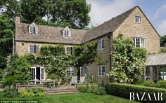 an old house with ivy growing on it's walls and windows, surrounded by greenery