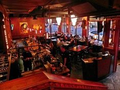 the inside of a restaurant with many tables and people sitting at their desks in it