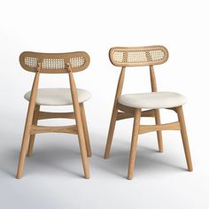 two wooden chairs sitting side by side on a white surface with one chair facing the other