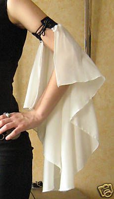 the woman is wearing a black dress with white ruffles on it and holding her hand out