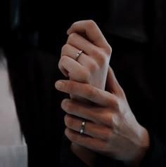 two hands holding each other with wedding rings on their fingers