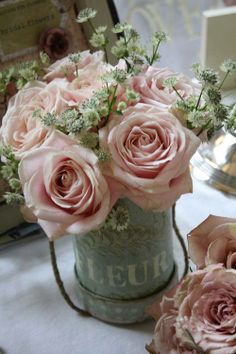 some pink roses are in a vase on a table