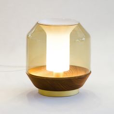 a light that is sitting on top of a table in front of a white wall