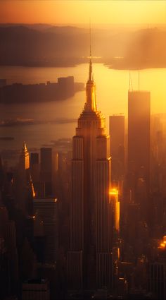 the empire building in new york city is lit up at sunset with bright yellow lights