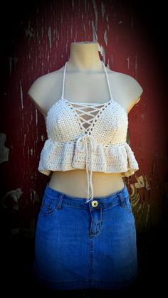 a mannequin wearing a white crochet top and blue denim miniskirt