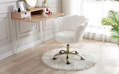 a white chair sitting on top of a wooden floor next to a desk with a mirror