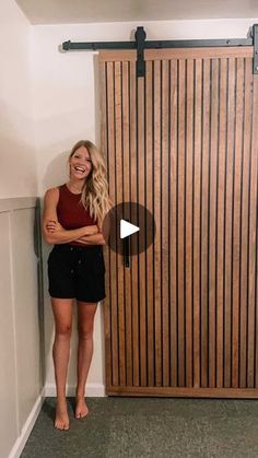 a woman standing in front of a wooden door