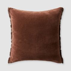 a brown pillow with fringe trim