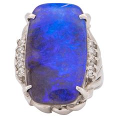 ♥ Rich Purple Blue Australian Boulder Opal Ring Platinum ♥ The face of the ring measures 18.9mm in width (East West direction), 25.5mm in length (North South direction), and sits 8mm tall from the finger. The band is 2.6mm wide. ♥ US size 6.5 (Free resizing up or down 1 size) ♥ Material: Platinum, 14.9g ♥ Gemstone: Solid Australian Boulder opal 15.29ct, diamond 0.155ctw ♥ Note: This is a preowned piece that may have signs of wear and tear, and minor discoloration due to its age. This piece may o Irene Neuwirth Jewelry, Boulder Opal Ring, Healing Crystal Ring, Opal Diamond Ring, Hippie Rings, Fairy Queen, Australian Boulder Opal, Bleu Violet, Irene Neuwirth