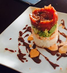 a white plate topped with lots of food on top of a wooden table next to a cell phone