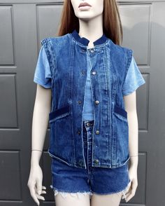 Vintage 80's denim vest with  Snap buttons down the front.  Navy blue ribbing around neck and front pockets.  Label:  Organically Grown.  .  Such a cool vest.  Has a small light whit spot on lower front. Measurements are taken with item laying flat so widths across must be doubled  Label says size small but please use measurements to see if it will work for you. Length = 23 1/2  in Across under arms =  19 1/2  in Across the bottom opening  =  18  in Please be sure to use the measurements to help Everyday Medium Wash Denim Vest With Button Closure, Casual Cotton Vest With Snap Buttons, Casual Button-up Vest For Everyday Wear, Casual Medium Wash Button-up Vest, Casual Cotton Denim Vest With Snap Buttons, Vintage Button-up Denim Vest For Spring, Dark Wash Button-up Denim Vest, Blue Denim Vest With Button Closure, Casual Denim Vest With Snap Buttons