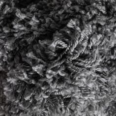 closeup of the texture of a gray sheep's wool fabric, with very little wrinkles