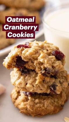 three oatmeal cookies stacked on top of each other next to a glass of milk