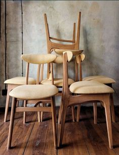 four chairs are stacked on top of each other in the middle of a wooden floor