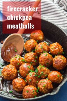 a skillet filled with meatballs next to a wooden spoon on top of a table