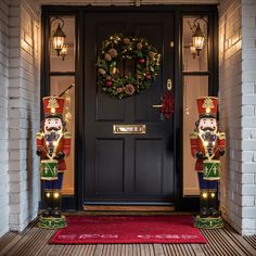 two nutcrackers are standing in front of a door with wreath on it