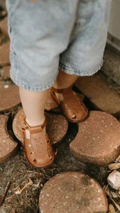 a person wearing sandals standing on stepping stones