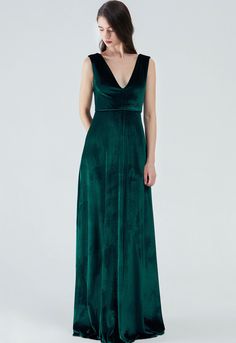 a woman wearing a green velvet dress with deep v - neckline and open back