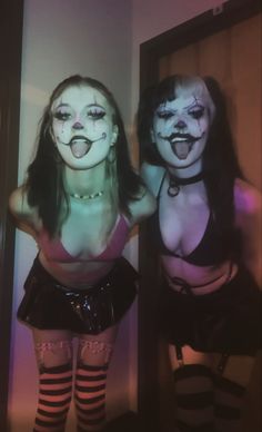 two women dressed up as clowns in front of a mirror with their mouths open