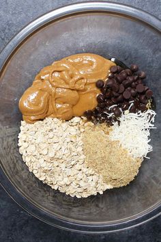 a glass bowl filled with oats, peanut butter, and chocolate chip toppings