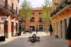 an empty courtyard with benches and potted trees