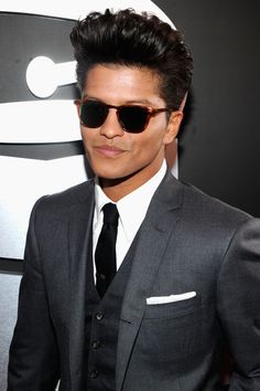 a man in a suit and sunglasses posing for the camera