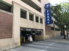 an empty parking garage on the side of a building next to a street sign that says park